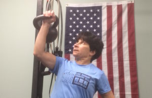 picture of Angie pressing a kettlebell overhead at Eric Moss Fitness, a personal training studio in the previous Boonton Township location