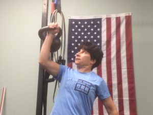 picture of Angie pressing a kettlebell overhead at Eric Moss Fitness, a personal training studio in the previous Boonton Township location